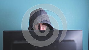 Man hacker in the hood hacking network concept. Unknown hacker criminal lifestyle breaks into computer protection on the