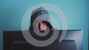 Man hacker in the hood hacking network lifestyle concept. Unknown hacker criminal breaks into computer protection on the