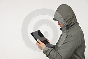 Man hacker wears hoodie, holds smart tablet. Concept, digital information security,