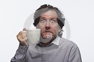 Man had too much coffee (holding mug), horizontal