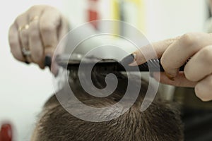 A man during a haircut. female hands of the master
