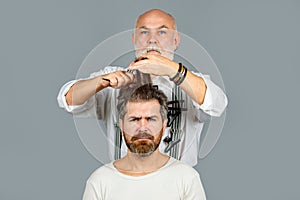 Man at the hairdresser getting a haircut. Hipster client in professional hairdressing salon. Professional barber styling