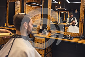 Man hairdresser making hairstyle for client.