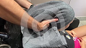 A man hairdresser washes woman's hair after dyeing her hair. Close-up