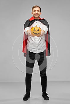 Man in halloween costume of vampire with pumpkin