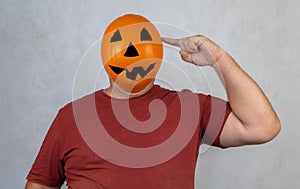 Man in a Halloween mask on a white background. person with orange pumpkin evil mask.
