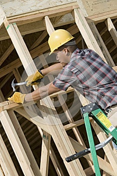 Man Hammering Nail On Wooden Formwork photo