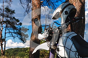 Man in a hammock on pine forest mountain, outdoor traveler relax, enduro off road motorcycle