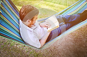 A man in a hammock reads a book