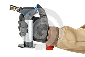 Man hand in black protective glove and brown uniform holding small butane torch isolated on white background