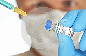 Man hand in blue nitrile glove hold small vial with chloroquine phosphate generic name, label own design not real product, to