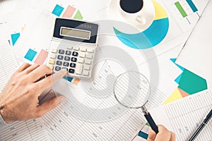 Man hand calculator with magnifier on document