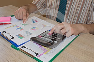 Man hand with calculator at workplace office. A businessman doing some paperwork using his calculator