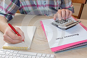 Man hand with calculator at workplace office. A businessman doing some paperwork using his calculator