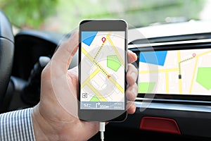 Man hand in car holding phone with navigation map