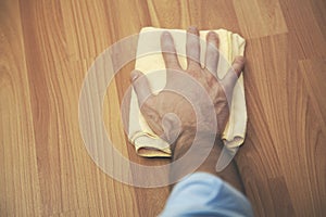 Man hand cleaning an hardwood floor with a microfiber cloth