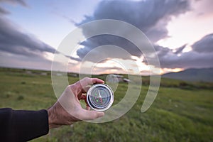 Man hand compass in field background