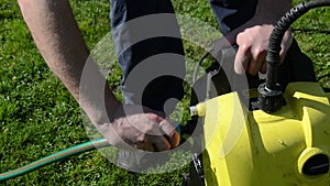 Man hand detach water hose to high pressure wash equipment