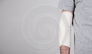 Man hand with elastic bandage on elbow