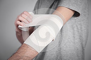 Man hand with elastic bandage on elbow