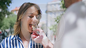 Man hand feeding woman romantic date nature closeup. Husband touching wife hair