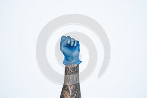 A man hand and gestures in Blue rubber glove shows fist scat sign isolated on white background
