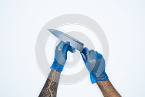 A man hand and gestures in Blue rubber glove shows knife isolated on white background