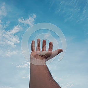 man hand gesturing on the blue sky