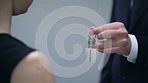 Man hand giving Fortune keys to woman, lucky chance to achieve wealth, closeup