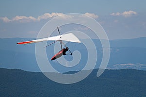 Man Hand-gliding in Mid Sky over Mointains on a Hot Summer Day photo