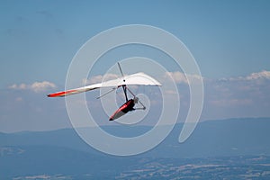 Man Hand-gliding in the Sky over Mointains on a Hot Summer Day photo