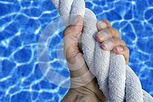 Man hand grab grip sport blue pool big rope