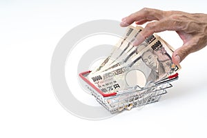 Man hand grabbing Japanese 10000 banknote in shopping basket on white background