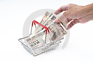 Man hand grabbing Japanese 10000 banknote in shopping basket on white background