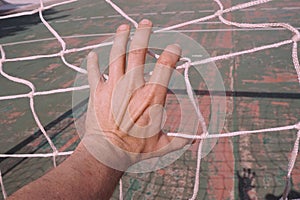 Man hand grabbing the rope net on the street