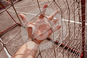 Man hand grabbing the rope net on the street