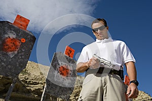 Man With Hand Gun Near Targets At Firing Range