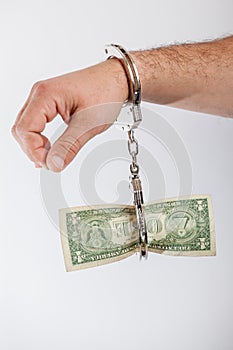 Man hand handcuffed to a one dollar banknote