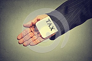 Man hand hiding tax card in a sleeve of a suit. tax evasion economy concept photo