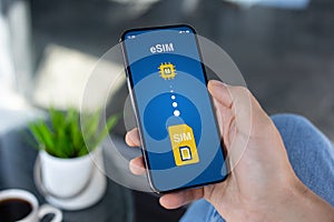 Man hand hold phone with Sim card replacement on eSim