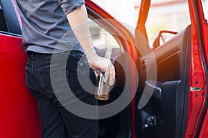 Man hand holding alcohol bottle already driver