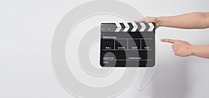 A man hand is holding black Clapper board or movie slate. it use in video production or cinema industry.It is white background