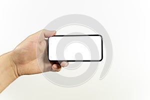 Man hand holding the black smartphone with blank screen and modern frameless design positions horizontal - isolated