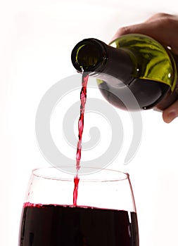 Man Hand holding Bottle filling Glass with Red Wine