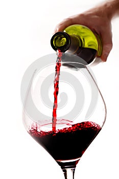 Man Hand holding Bottle filling Glass with Red Wine