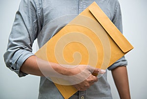 Man hand holding brown envelope on white background