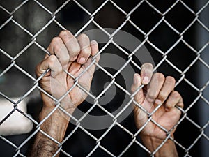 Man hand holding on chain link fence to remember Human Rights Da
