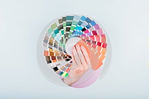 man hand holding a color guide palette on a blue background