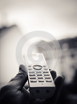 Man hand holding cordless phone calling home office