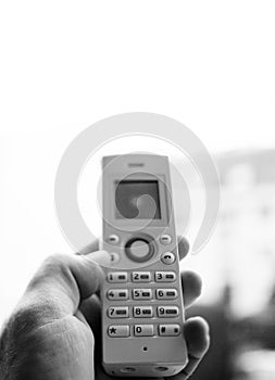 Man hand holding cordless phone calling home office photo